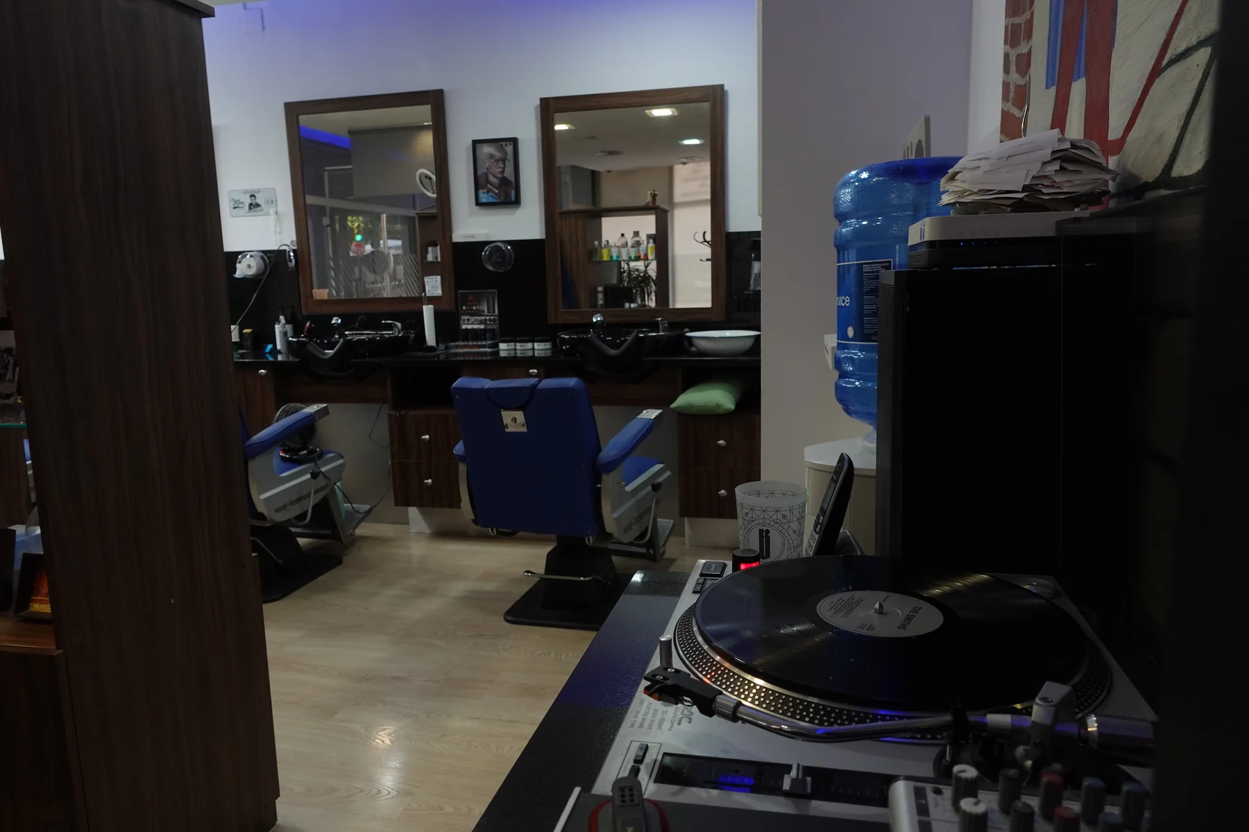 Un tocadiscos junto a los espejos y sillones de la peluquería
